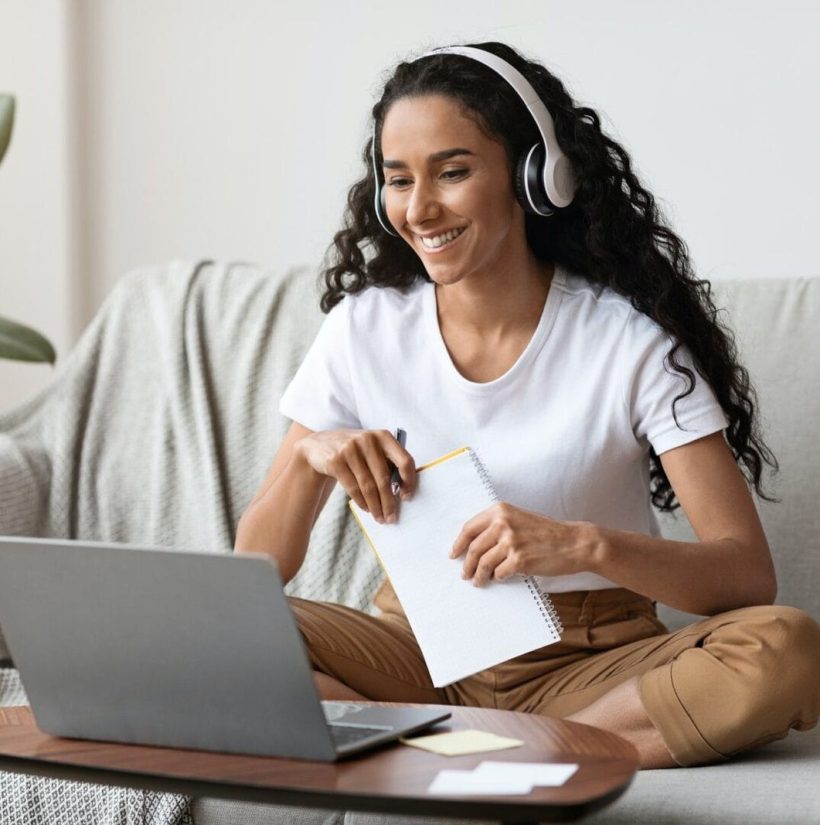 cheerful-lady-attending-online-course-using-laptop-and-wireless-headset.jpg